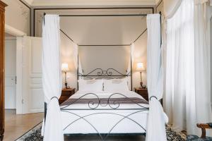 um quarto com uma cama de dossel e cortinas brancas em Boutique Hotel 1905 em Xanthi