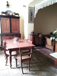 Beatrice House Galle Fort في غالي: غرفة طعام مع طاولة وكراسي خشبية