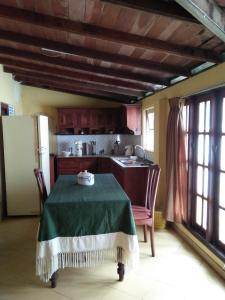 a kitchen with a table and a refrigerator at Beatrice House Galle Fort in Galle