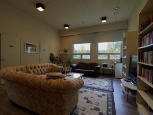 a living room with a large couch and a television at Hostel Pielinen in Vuonislahti