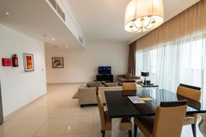 a living room with a dining table and a couch at Damac Capital Bay - Business Bay in Dubai