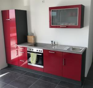 a kitchen with red cabinets and a sink at The Penthouse in Kaiserslautern