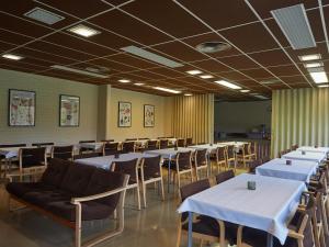 a dining room with white tables and chairs at Hostel Pielinen in Vuonislahti