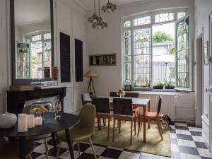 uma sala de jantar com mesa, cadeiras e vitrais em Une maison en ville, Hyper Centre ville, Spa em Amiens