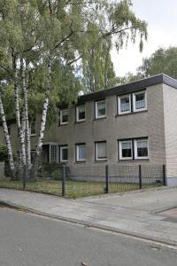 um grande edifício de tijolos com árvores em frente em Am Klinikum em Solingen