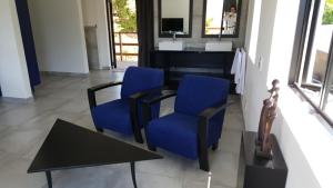 uma sala de estar com duas cadeiras azuis e uma mesa em Dreamhouse Guest House em Hout Bay