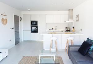 a kitchen and living room with a couch and a table at Saltwater Suites at Fistral in Newquay