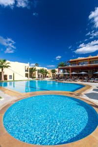 uma grande piscina com água azul num resort em Atlantis Beach Hotel em Retimno
