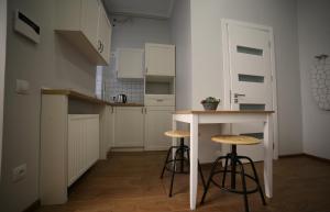 uma pequena cozinha com uma mesa e bancos em Del Rey Comfort em Lviv