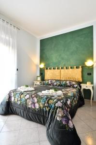 テルモリにあるB&B Le Stanze del Soleの緑の壁のベッドルーム1室(大型ベッド1台付)