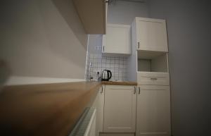uma cozinha com armários brancos e uma bancada em Del Rey Comfort em Lviv