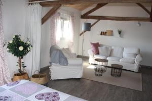 a living room with a white couch and a table at le petit durbec in La Force