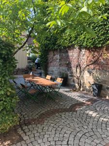 einen Holztisch und Stühle auf einer Backsteinterrasse in der Unterkunft Hotel Fulda in Hannoversch Münden