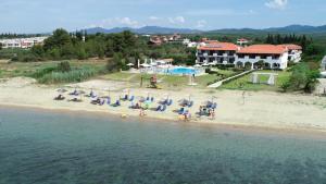 ゲラキニにあるAlkinoos Beach Hotelのビーチの空中を望む客室で、椅子とパラソルが備わります。