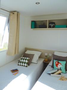 カネ・アン・ルシヨンにあるMobilhome canetのベッドルーム1室(ツインベッド2台、窓付)