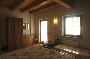 1 dormitorio con 1 cama, vestidor y ventana en Appartamenti Al Lumin, en Val di Zoldo