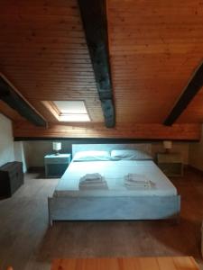 コンメッツァドゥーラにあるMansarda 2 del Capitelの木製の天井の客室のベッド1台分です。