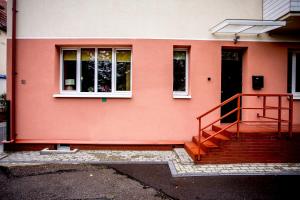 una casa rosa con una scala di fronte di Liepu 37 a Klaipėda