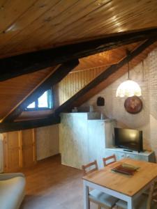 a dining room with a table and a kitchen at Mansarda 2 in Commezzadura