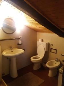 コンメッツァドゥーラにあるMansarda 2 del Capitelのバスルーム(洗面台、トイレ、鏡付)