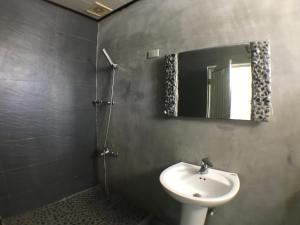 a bathroom with a sink and a mirror at Donghe surf shop & Hostel in Donghe