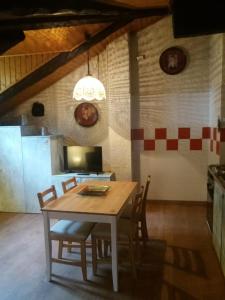eine Küche mit einem Tisch und Stühlen im Zimmer in der Unterkunft Mansarda 2 del Capitel in Commezzadura