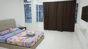 um quarto com uma cama com um cobertor colorido em F.A Guesthouse Pasir Gudang em Pasir Gudang