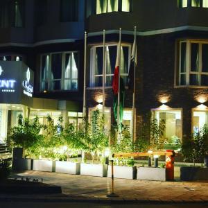 ein Gebäude mit einer Bank in der Nacht davor in der Unterkunft Regent Hotel Apartments in Kuwait