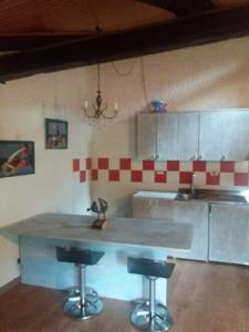 a kitchen with a counter and two bar stools at Maso del Capitel in Commezzadura