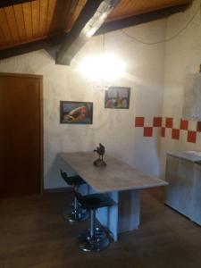 a table in a kitchen with two bar stools at Maso del Capitel in Commezzadura