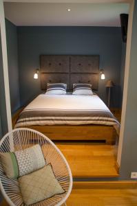 スパにあるLa Suite Des Pervenchesのベッドルーム(大型ベッド1台、椅子付)