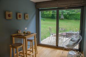 a room with a patio door with a table and chairs at La Suite Des Pervenches in Spa