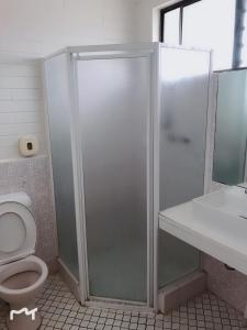 uma casa de banho com um chuveiro, um WC e um lavatório. em Bananatown Motel em Coffs Harbour