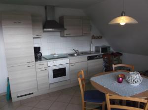 a kitchen with a table and a sink and a stove at Ferienwohnung Anna in Süderstapel