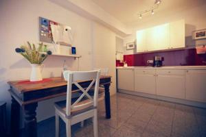 杜塞道夫的住宿－Apartment in Unterbach，厨房配有木桌和白色椅子