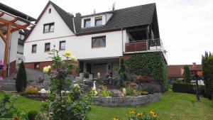 a white house with a garden in front of it at FEWO-Frammersbach in Frammersbach
