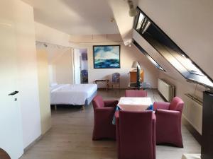 une chambre d'hôtel avec un lit, des tables et des chaises dans l'établissement Hotel Claridge, à Blankenberge