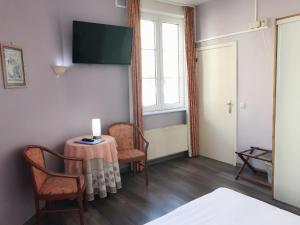 a room with a table and two chairs and a window at Hotel Claridge in Blankenberge