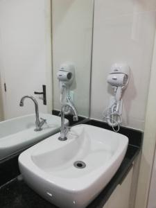 a bathroom with a sink and two hair dryers at Flats Dunas Cabo Frio in Cabo Frio