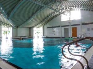 a large swimming pool with blue water in a building at Carmels Caravan Borwick Lakes in Carnforth