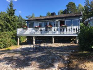 uma casa com um deque e cadeiras em Family house 50 meters to the ocean em Buvik