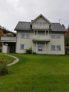 ein großes weißes Haus mit einem großen Hof in der Unterkunft Solbakken 27 Apartment in Lyngseidet