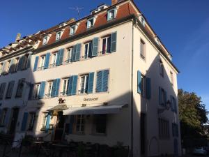 un edificio blanco con ventanas con contraventanas verdes en Il Piano Nobile, en Colmar