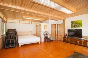 a bedroom with a bed and a flat screen tv at The Hanok in Jeonju