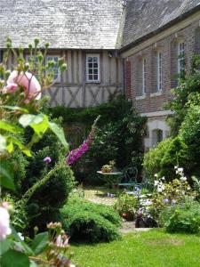 a garden in front of a house with flowers at Le Clôs Ste Anne in Eu