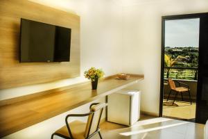 a home office with a desk and a television at Hotel Recreio São Jorge in Jaboticabal