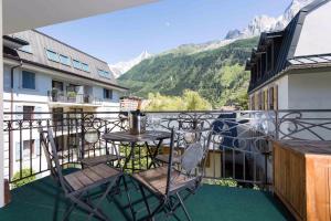 d'un balcon avec une table et des chaises donnant sur les montagnes. dans l'établissement Le Paradis ski apartment - Chamonix All Year, à Chamonix-Mont-Blanc