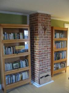 two book shelves in a room with a brick wall at Gîte La Richardière in Godbout