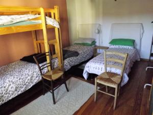 a room with three bunk beds and two chairs at B&b Col del Vin in Belluno