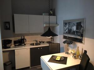戈斯拉爾的住宿－Appartementhaus Klingebiel，厨房配有水槽和带电视的桌子。